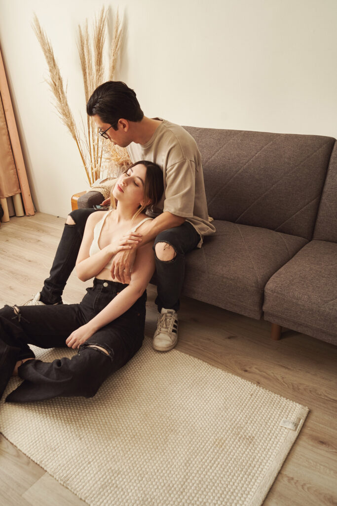 Gaby and Me are in a cozy living room setting with Gaby lounging on the floor and I am sitting on the couch both appearing relaxed and intimate.